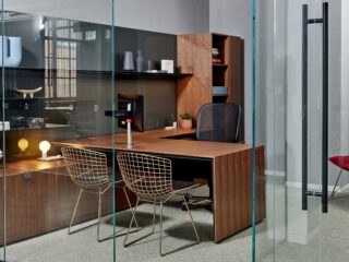This photo features a Knoll executive office, with a sit-to-stand cove desk and two gold finish Bertoia side chairs.